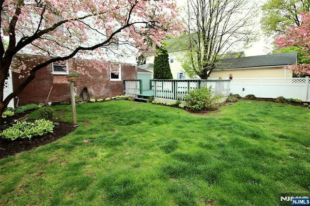 view of yard with a wooden deck and fence