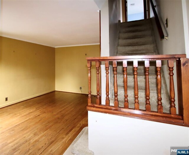 staircase with baseboards, wood finished floors, and crown molding