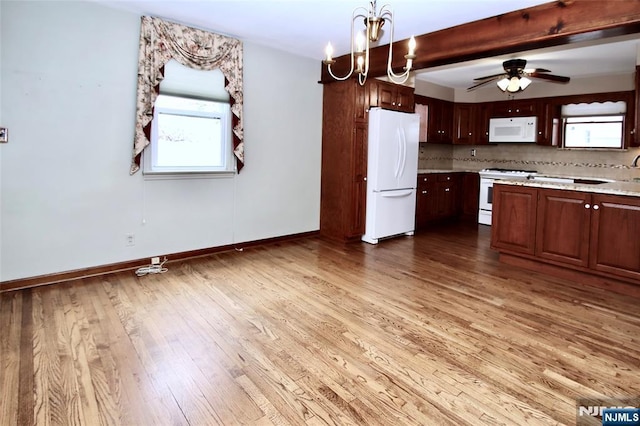 kitchen with white appliances, decorative light fixtures, baseboards, wood finished floors, and ceiling fan with notable chandelier