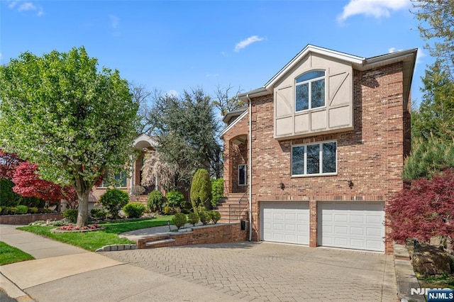 tudor house with brick siding, a garage, and driveway
