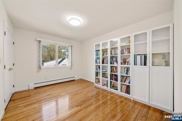 interior space with light wood-type flooring, baseboards, and baseboard heating