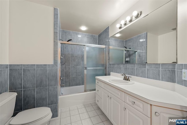 full bathroom featuring tile patterned flooring, vanity, toilet, and tile walls