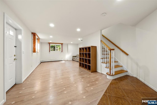 interior space with baseboard heating, recessed lighting, baseboards, light wood-type flooring, and stairway