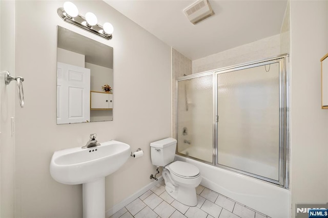 bathroom with toilet, tile patterned floors, baseboards, combined bath / shower with glass door, and visible vents