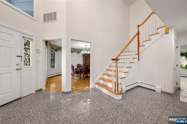 foyer featuring a notable chandelier, visible vents, granite finish floor, and stairway