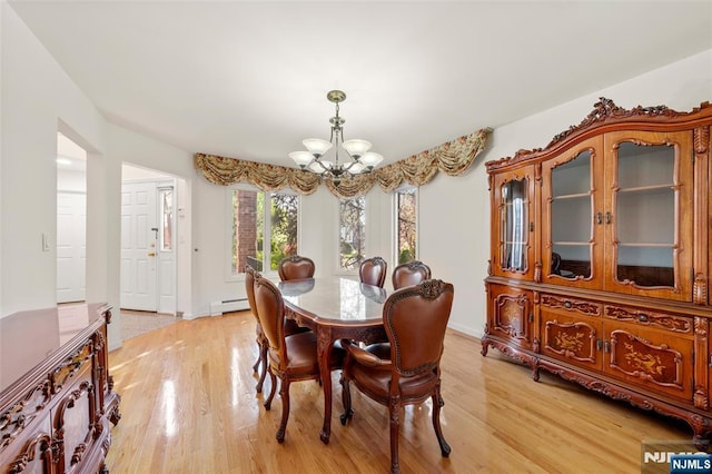 dining space featuring an inviting chandelier, baseboards, a baseboard radiator, and light wood finished floors