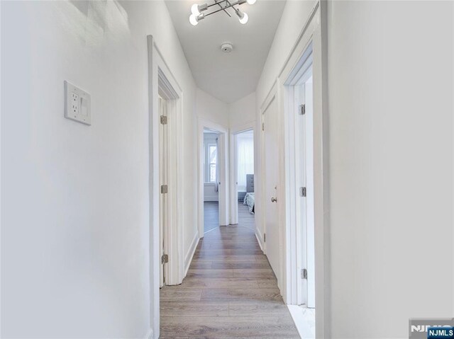 hallway with light wood-style flooring and baseboards