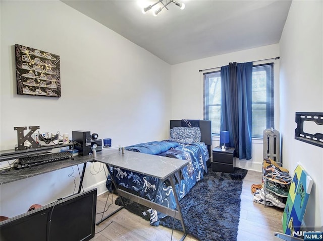 bedroom featuring wood finished floors and vaulted ceiling