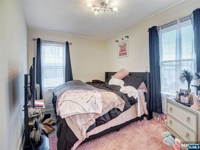 bedroom featuring a notable chandelier and light colored carpet