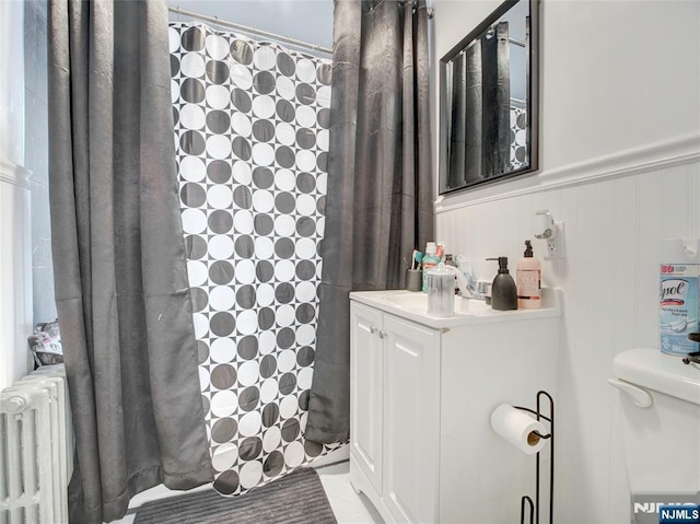 bathroom featuring radiator, toilet, a shower with curtain, and vanity