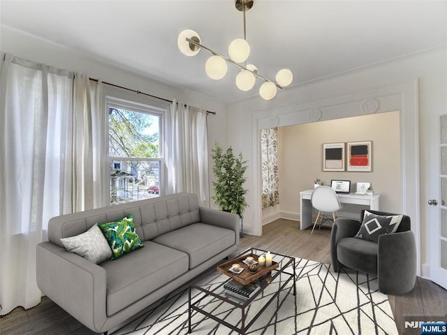 living room with baseboards, light wood-type flooring, and a notable chandelier