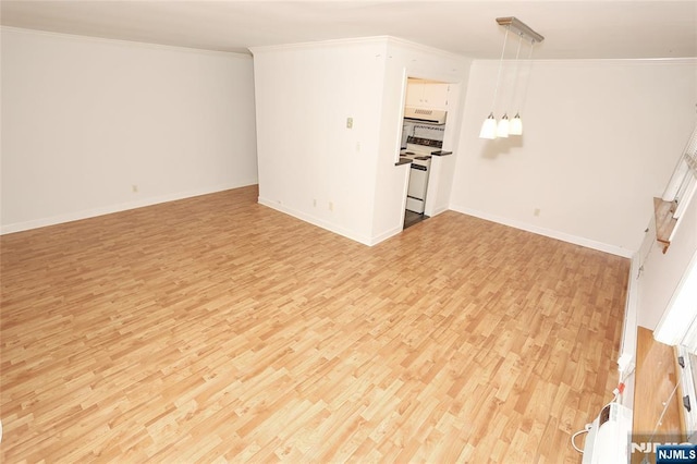 unfurnished living room with light wood-style floors, crown molding, and baseboards