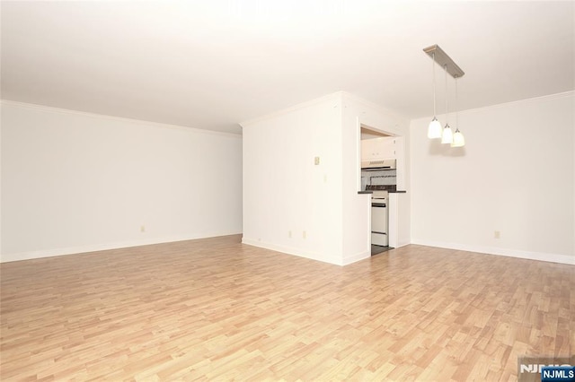 unfurnished living room with light wood-style floors, crown molding, and baseboards