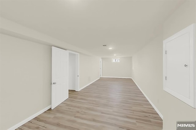 finished below grade area with recessed lighting, baseboards, and light wood-style floors