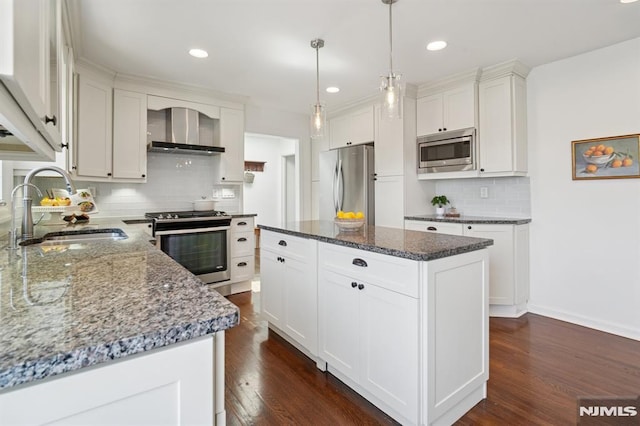 kitchen with a sink, decorative backsplash, wall chimney range hood, appliances with stainless steel finishes, and dark wood finished floors
