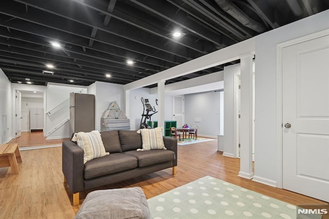 living area featuring baseboards and light wood-type flooring