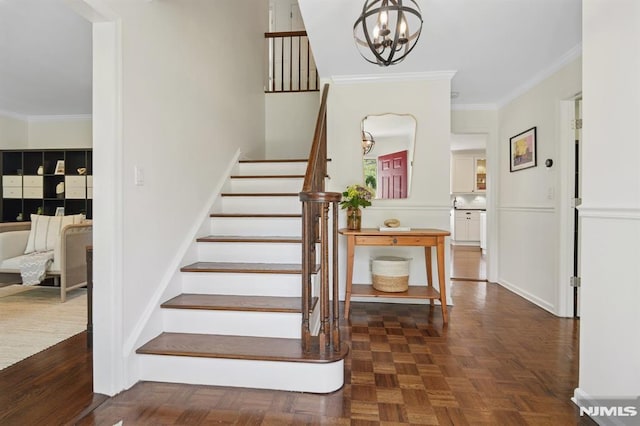 stairway with ornamental molding and a notable chandelier