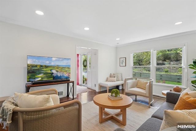 living area with plenty of natural light, light wood finished floors, and crown molding