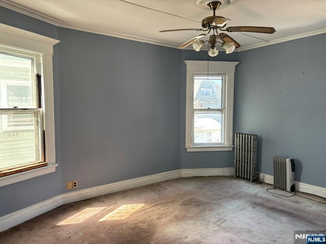 carpeted spare room with radiator, crown molding, and plenty of natural light