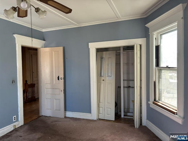 unfurnished bedroom featuring carpet floors, a closet, crown molding, and baseboards