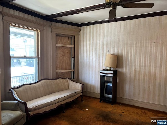 living area with ceiling fan, carpet, and baseboards