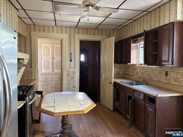 kitchen featuring appliances with stainless steel finishes, a drop ceiling, open shelves, and wallpapered walls