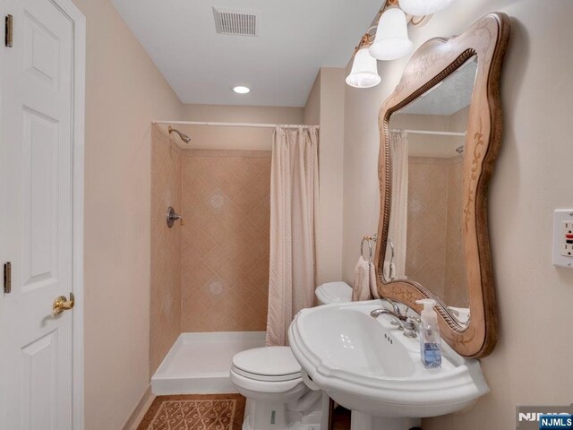 6 Knollwoods, Oakland, NJ 07436 - bathroom with a sink, visible vents, baseboards, toilet, and tiled shower