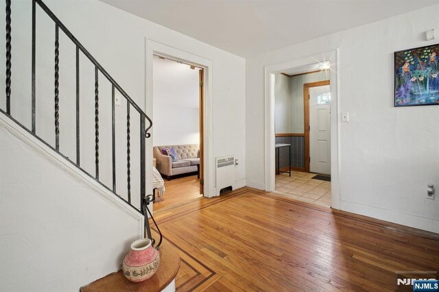 884 Helen St, Teaneck, NJ 07666 - foyer with light wood finished floors, stairway, and baseboards
