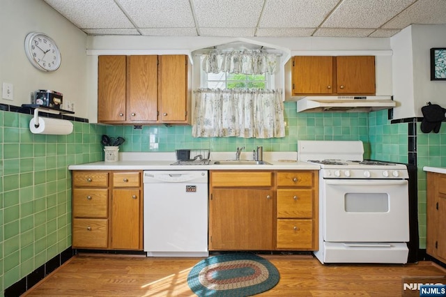 884 Helen St, Teaneck, NJ 07666 - kitchen with white appliances, under cabinet range hood, a sink, light wood-style floors, and tile walls