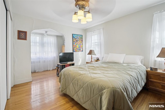 884 Helen St, Teaneck, NJ 07666 - bedroom with light wood finished floors, arched walkways, ceiling fan, and baseboards