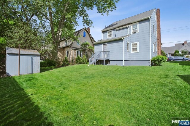 884 Helen St, Teaneck, NJ 07666 - back of property featuring a storage unit, a yard, a chimney, and an outbuilding