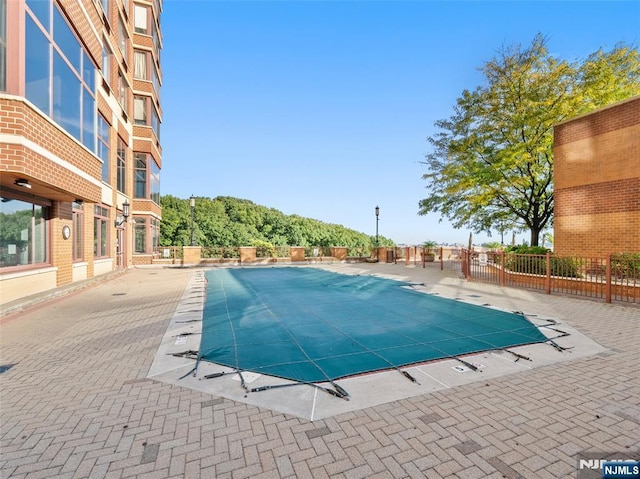 community pool featuring a patio and fence