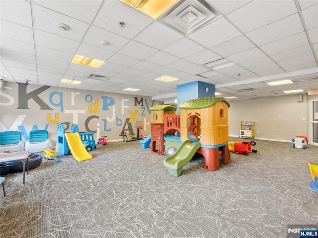 playroom featuring a drop ceiling, carpet, and baseboards
