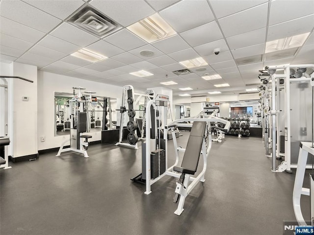 gym featuring visible vents, a drop ceiling, and baseboards