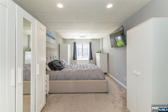 carpeted bedroom with recessed lighting, baseboards, and a paneled ceiling