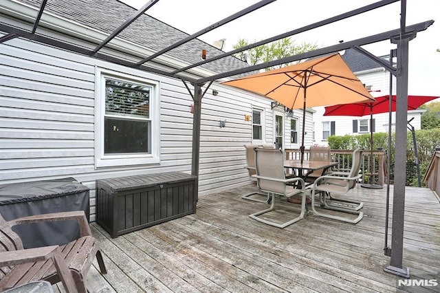 deck featuring outdoor dining space and a pergola