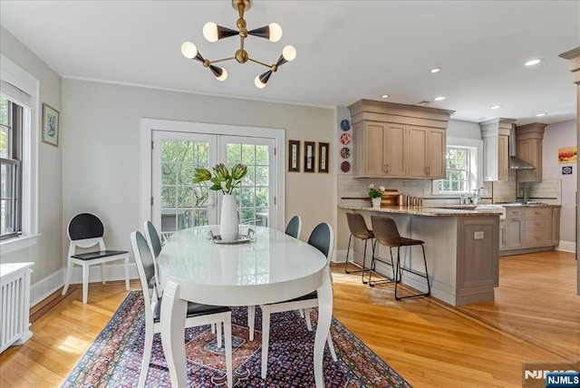 dining room with baseboards, recessed lighting, light wood-style flooring, and a chandelier