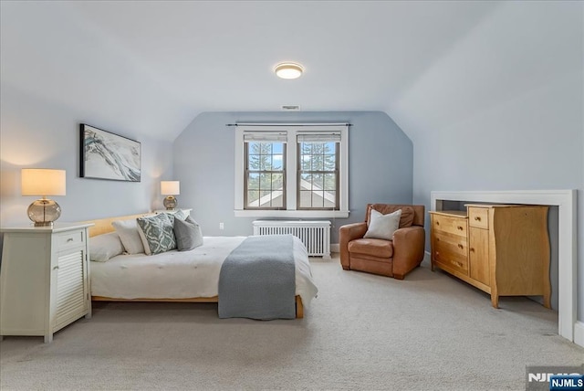 carpeted bedroom with vaulted ceiling and radiator heating unit