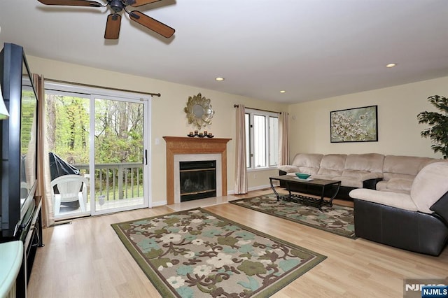 living room featuring recessed lighting, wood finished floors, ceiling fan, and a fireplace with flush hearth
