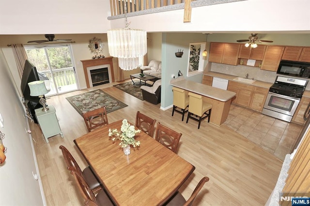 dining space with a ceiling fan and light wood finished floors