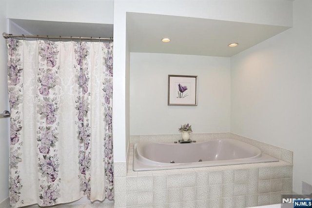 bathroom with recessed lighting and a bath
