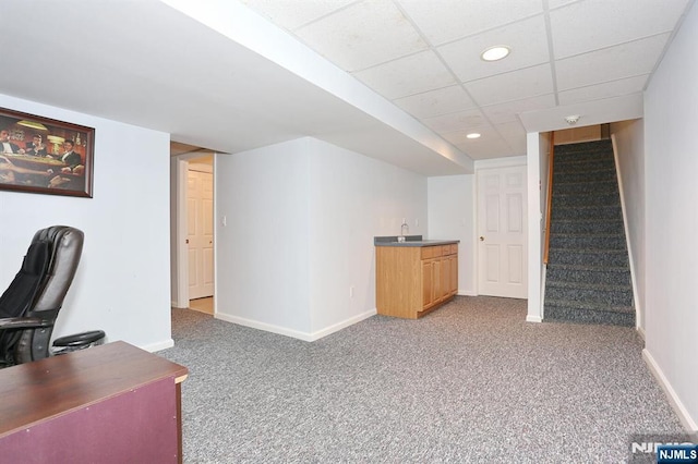 carpeted office space with recessed lighting, indoor wet bar, a paneled ceiling, and baseboards