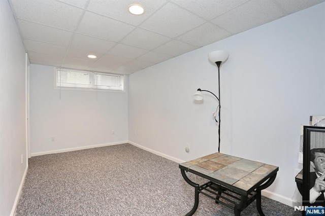 basement featuring baseboards, carpet, and a drop ceiling