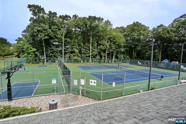 exterior space featuring a tennis court, community basketball court, and fence