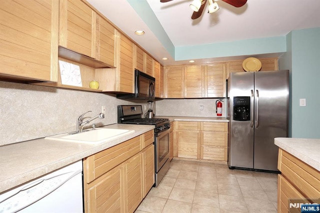 kitchen with light countertops, stainless steel appliances, decorative backsplash, and a sink