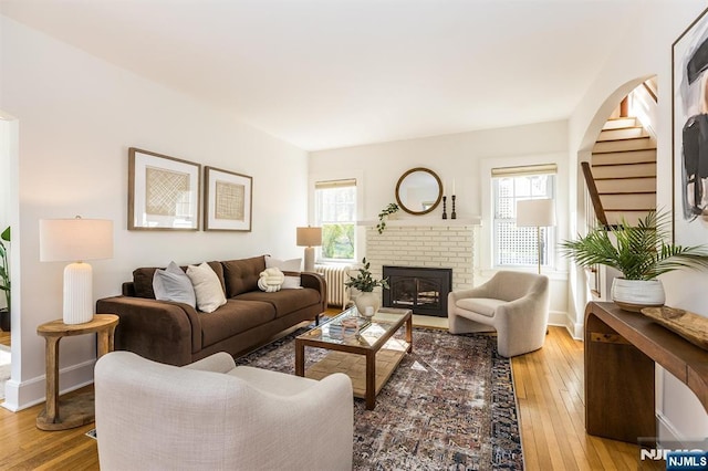 living room with stairway, baseboards, and wood-type flooring