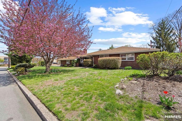 single story home with brick siding and a front lawn