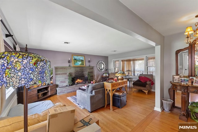 living area featuring light wood-style flooring and a fireplace