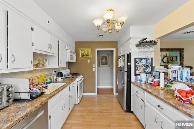 kitchen featuring tasteful backsplash, light wood-style flooring, white cabinets, a chandelier, and white appliances