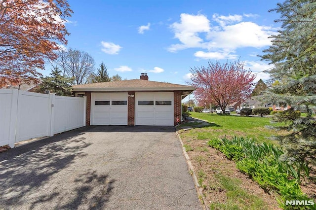 garage with fence and driveway